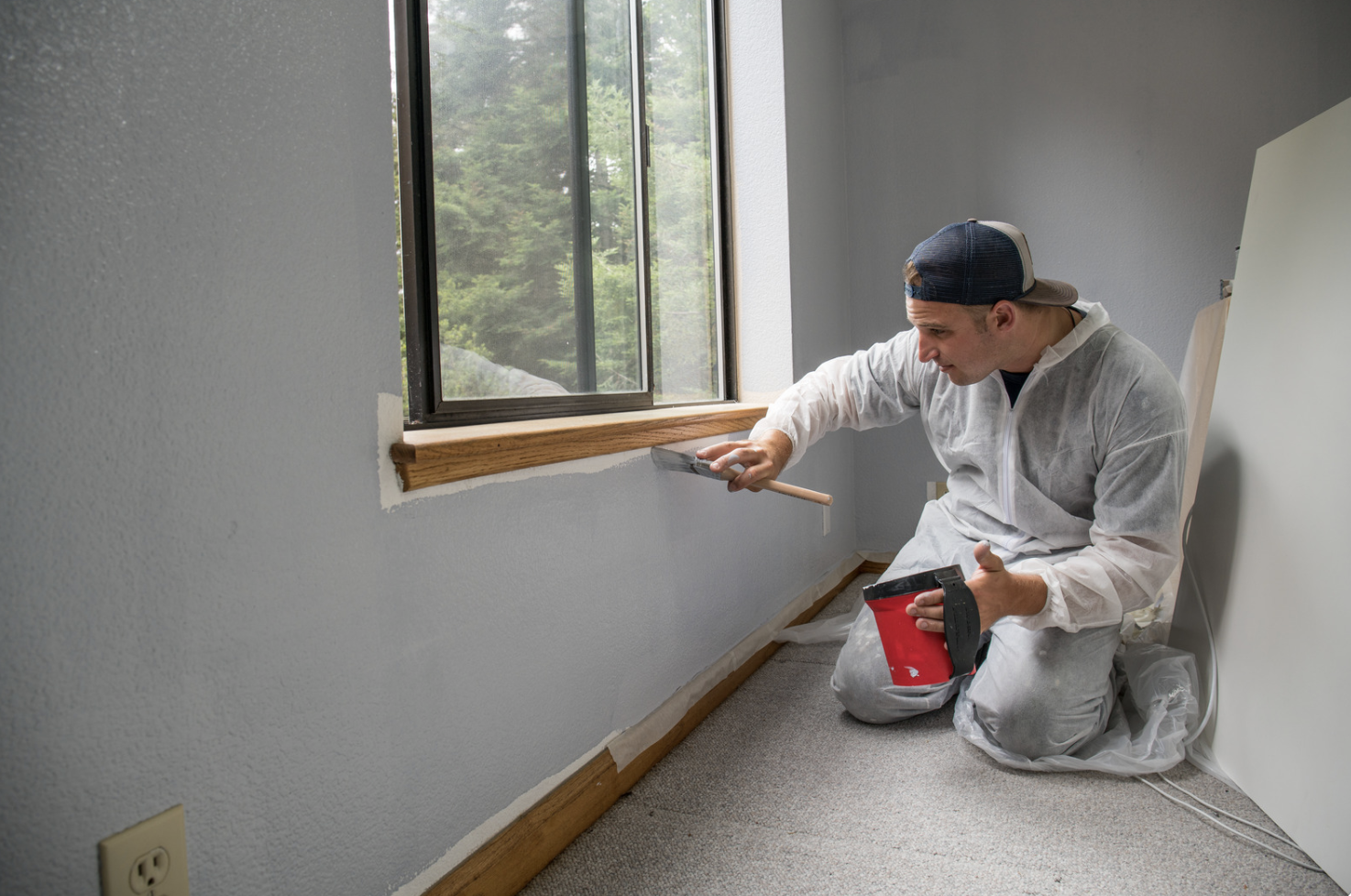 Interior painter applying a fresh finish near a window